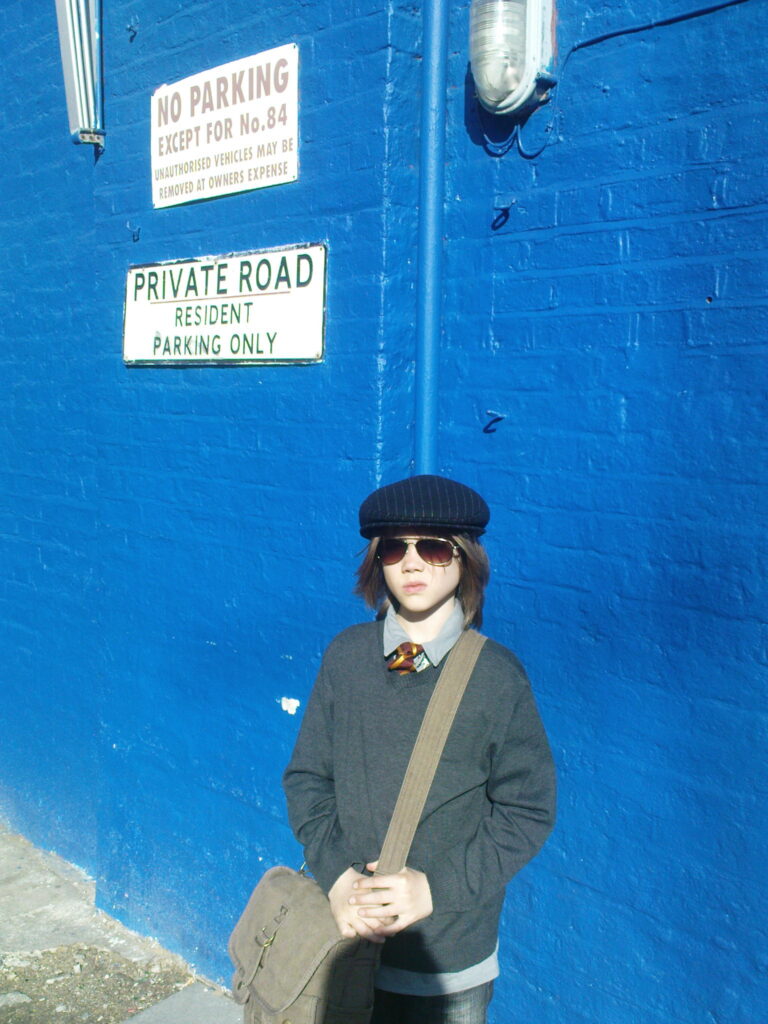 Kind vor blauer Wand