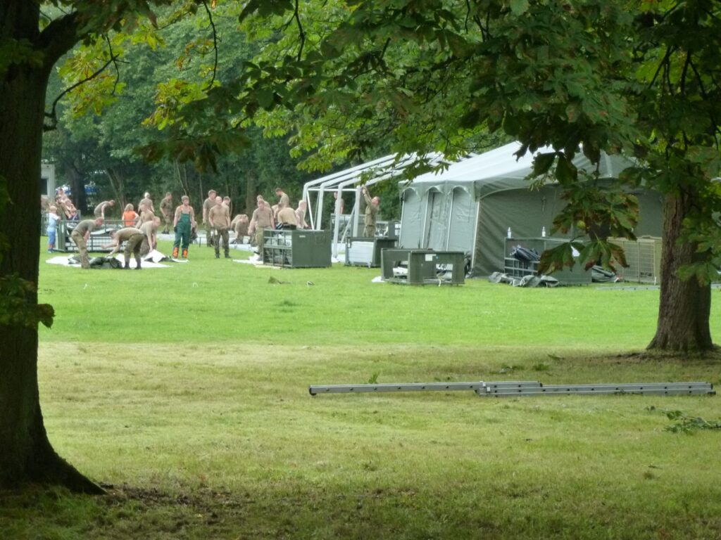 Bundeswehr-Soldaten bauen grüne 10-Personen-Zelte auf.