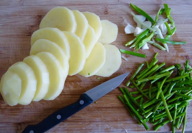 geschnittene Kartoffeln, Zwiebeln, Spargel mit Messer auf Brett